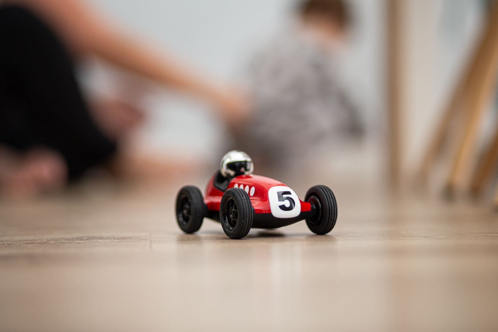A red model race car on a neutral background